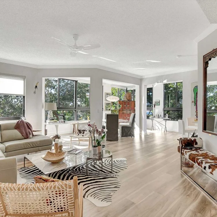 Open living and dining area with patterned seating and large windows
