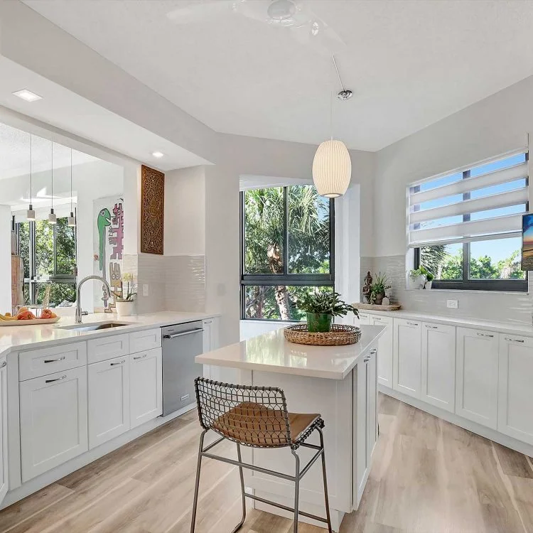 A bright kitchen with garden views and a warm woven chair