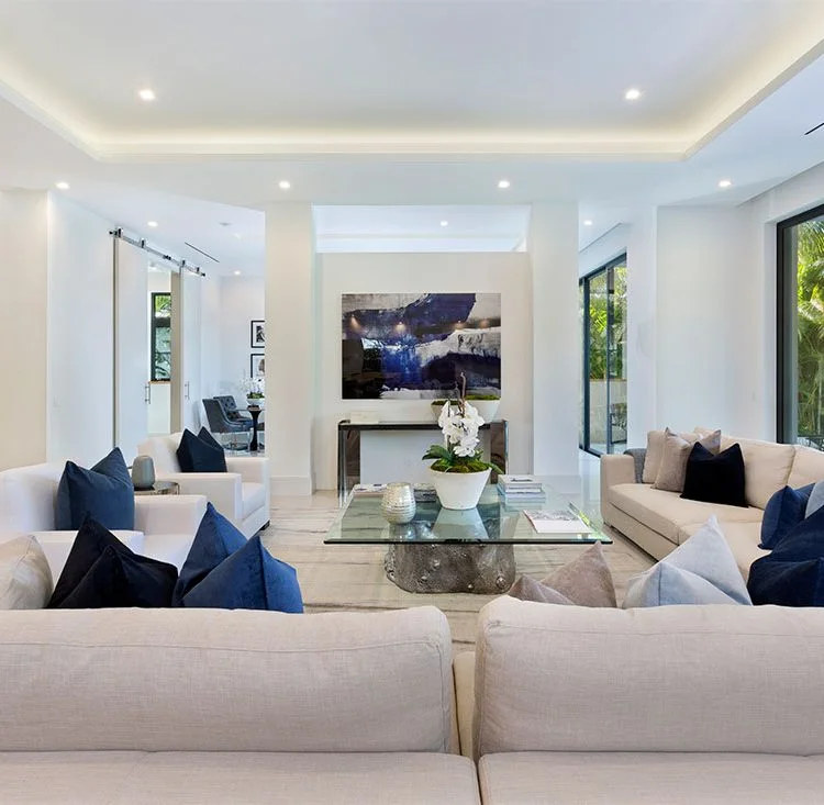 Pale sofas and navy cushions arranged around a glass coffee table