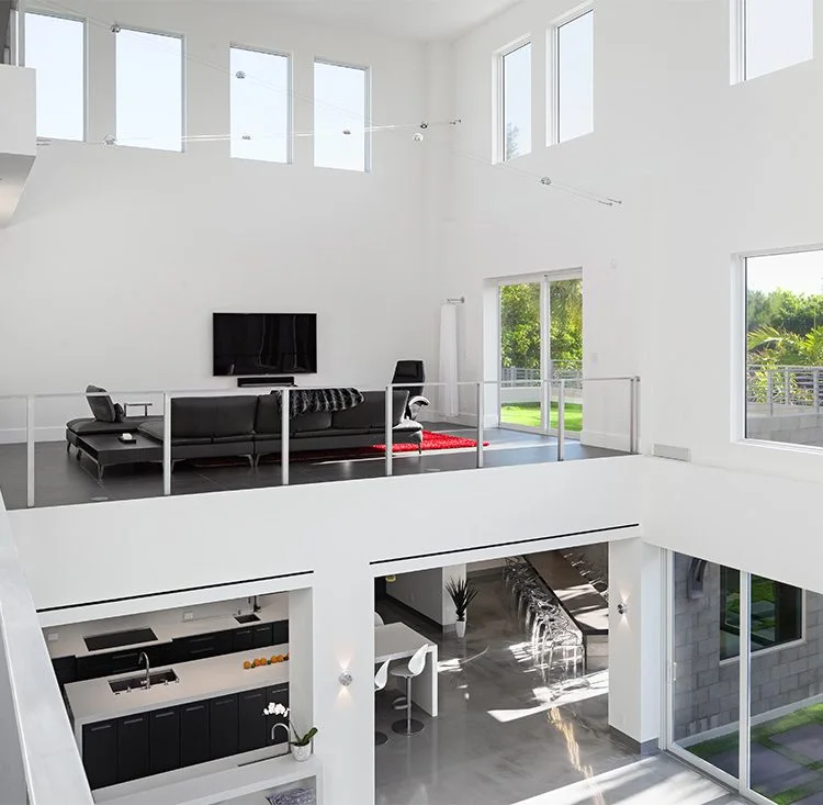 Open upper-level sitting area overlooking a black-and-white kitchen
