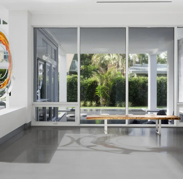 Pale entry hall with a narrow wood bench and large garden-facing windows