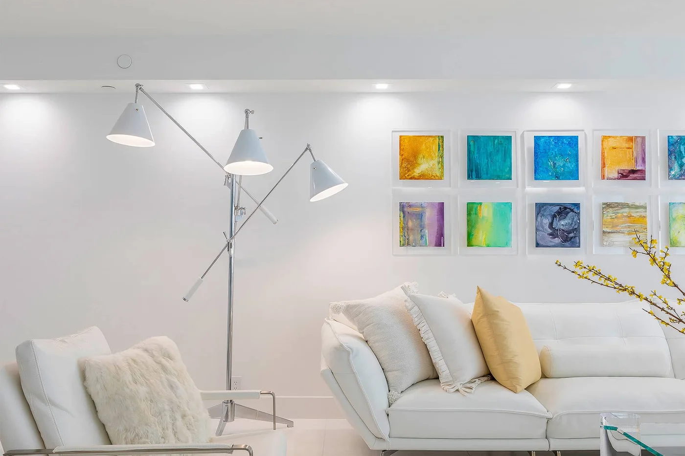 A coastal sitting room with colorful artwork and sculptural lighting